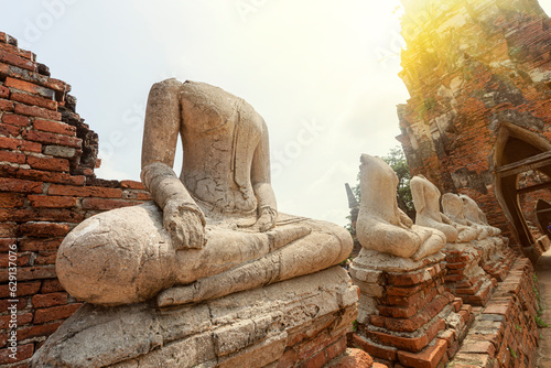 Ancient buddha is broken,old Buddha meditation, Buddha statue has destroy, no head Buddha statue. Buddha statue without head on brick wall of ancient Wat Mahathat, Ayutthaya province , Thailand. photo