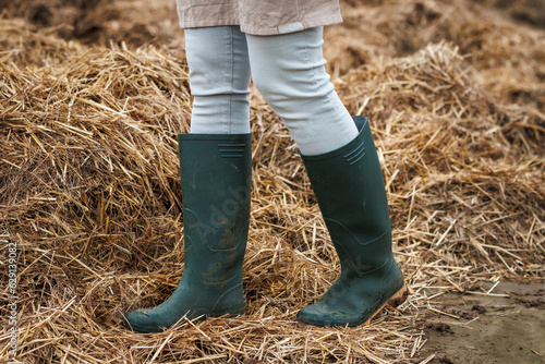 Rubber boot protective workwear. Farmer standing at organic manure agricultural fertilizer photo