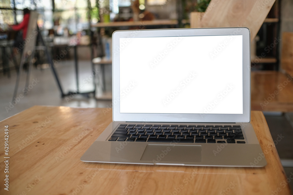 Laptop with Mock up blank screen on wooden table in front of coffeeshop cafe space for text. product display montage- technology concept Laptop with Mock up blank screen on wooden table in front of coffeeshop cafe space for text. product display montage- technology concept