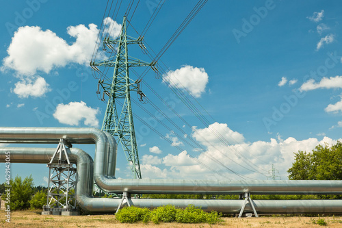 pipeline and power lines against the background of blue sky and clouds