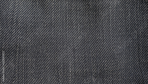 Dark gray denim background. The texture of black fluted denim. Background of black jeans.