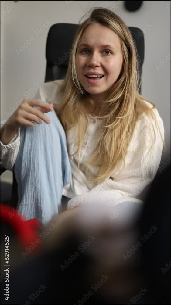 blogger girl sits in an office chair and speaks expressively to the camera. vertical video blogger girl sits in an office chair and speaks expressively to the camera. vertical video
