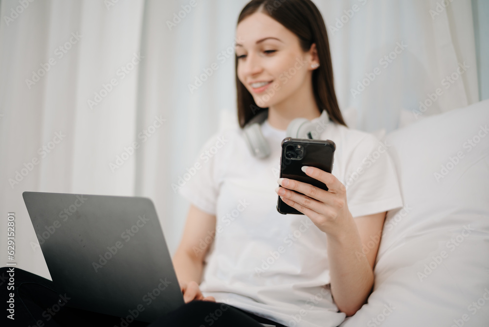 Beautiful young woman on a white bed with coffee cub and using smart phone at home. lifestyle concept. Beautiful young woman on a white bed with coffee cub and using smart phone at home. lifestyle concept.