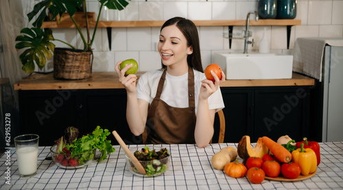 young woman with cutting board of cut lettuce at kitchen. healthy food concept.