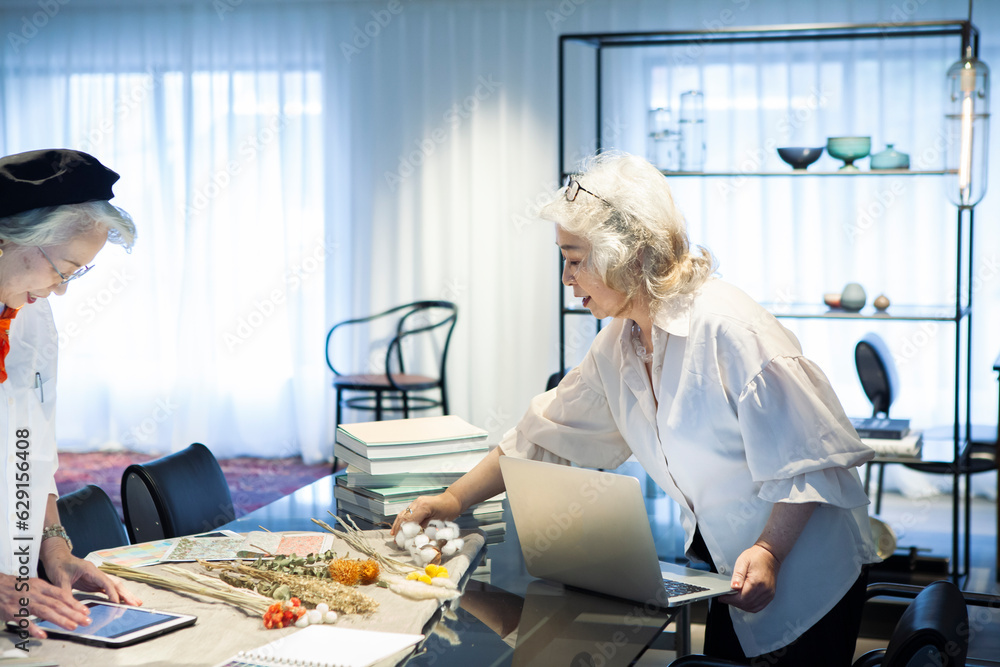 Obraz premium ドライフラワーのネット販売をするシニア女性の経営者たち