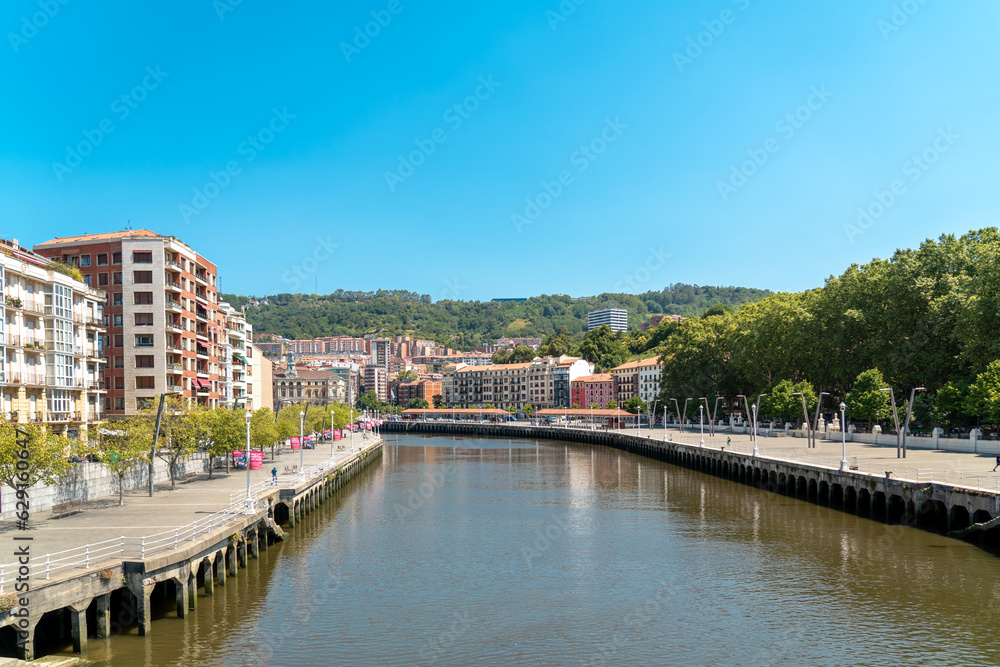 Bilbao, SPAIN - July 19 2022: Promenade area of the River Nervion. In background the old city of Bilbao in front plane the river Nervion. Travel destination in North of Spain, Basque Country