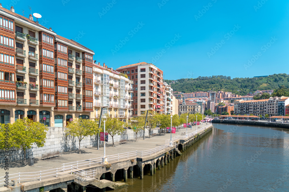Bilbao, SPAIN - July 19 2022: Promenade area of the River Nervion. In background the old city of Bilbao in front plane the river Nervion. Travel destination in North of Spain, Basque Country