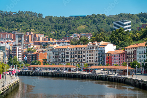 Bilbao, SPAIN - July 19 2022: Promenade area of the River Nervion. In background the old city of Bilbao in front plane the river Nervion. Travel destination in North of Spain, Basque Country