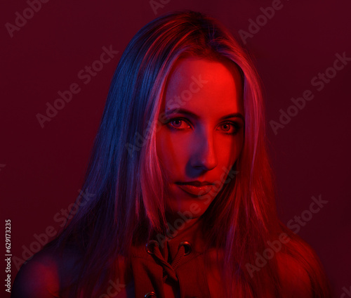 Portrait of a woman with colored light and dark background.