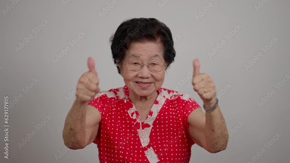 ortrait cheerful smiling Asian senior woman wear glasses grey hair over isolated white background and excited doing winner, clap hands, thumb up, smiling celebration for success. ortrait cheerful smiling Asian senior woman wear glasses grey hair over isolated white background and excited doing winner, clap hands, thumb up, smiling celebration for success.