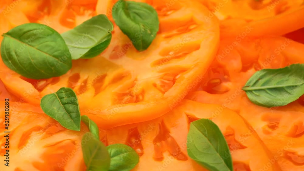 slices of yellow juicy tomato with basil leaf , rotation in circle. background yellow tomato, Turning. selective focus. seasonal vegetables slices of yellow juicy tomato with basil leaf , rotation in circle. background yellow tomato, Turning. selective focus. seasonal vegetables