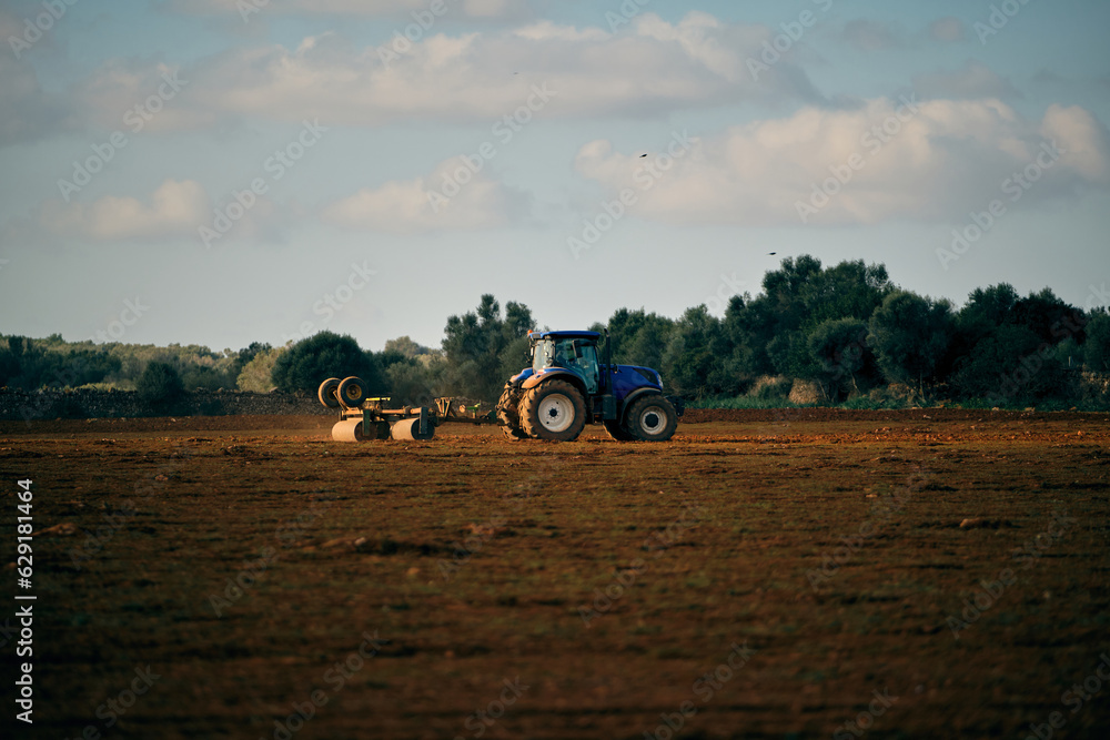 Fototapeta premium Tractor on field in countryside
