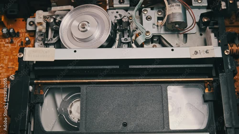 VHS video tape putting inside a VCR recorder and plays. Vintage VHS