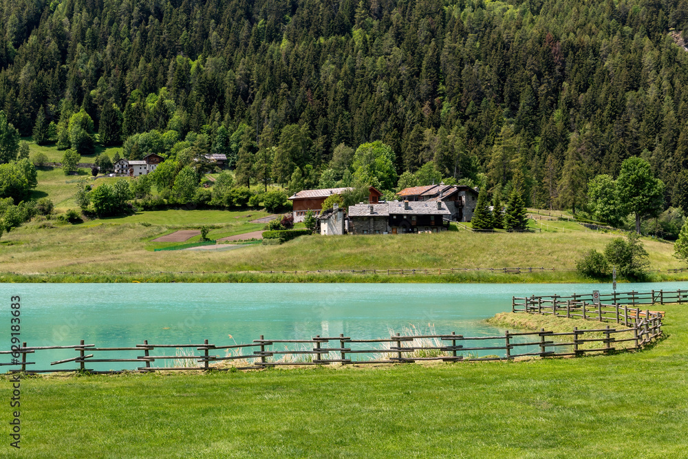 Small alpine lake and rural houses in Valle D'Aosta, Italy.