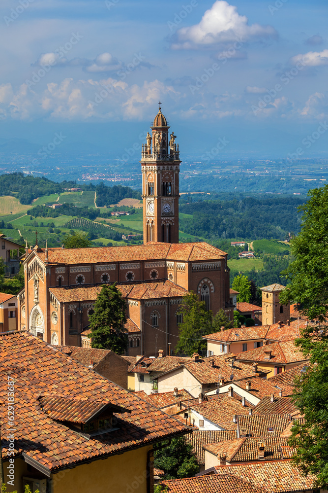 Catholic church among houses with red roofs in small italian town.