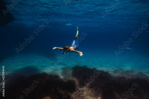 Fototapeta Naklejka Na Ścianę i Meble -  Boy swimming underwater in sea