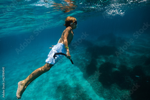 Boy in diving mask swimming underwater