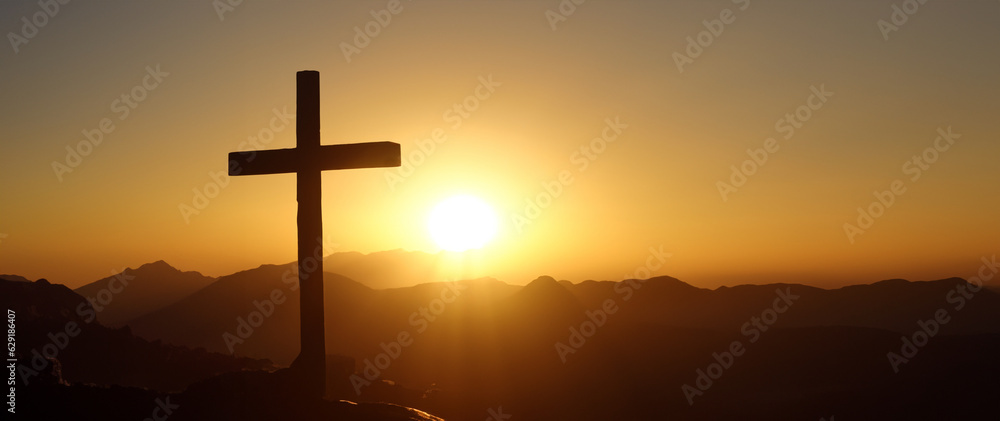 Wooden cross on the hill at sunset