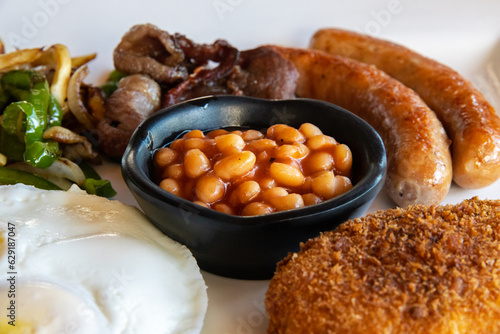 American Breakfast with Eggs, Sausages, Bacon, Beans, Hash Brown Potatoes and Sauted Vegetables