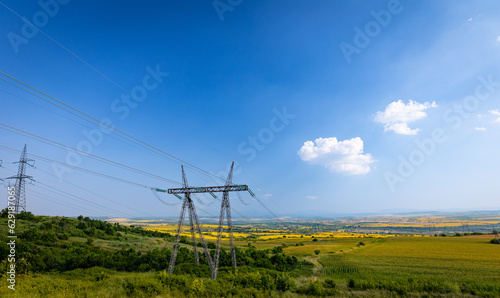 Massive electric power pylons on a hill next to agriculture fields in central Bulgaria. © Ivelin