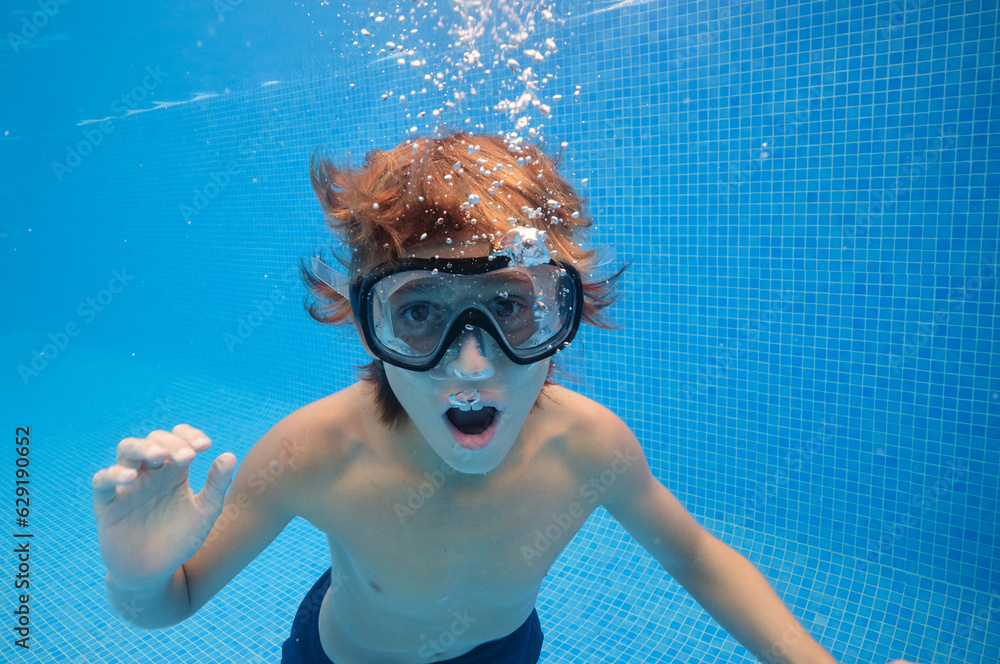 Boy with mouth opened swimming in pool