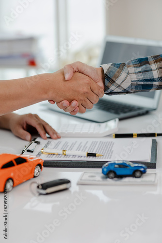 Car dealership, holding car keys to customer, new owner after signing lease contract, purchase contract in document, car sale contract. © NanTua