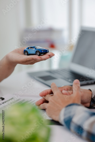 Car dealership  holding car keys to customer  new owner after signing lease contract  purchase contract in document  car sale contract.