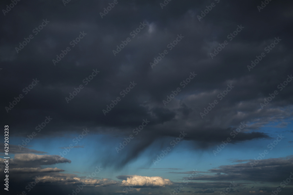 Epic Dramatic storm dark grey cumulus rain clouds against blue rainy sky background texture, thunderstorm