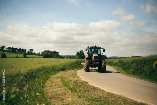 Billede på lærred tractor conduciendo por camino asfaltado