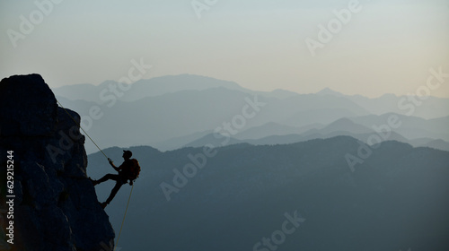 Young Mountaineer Climbing to the Top with a Rope