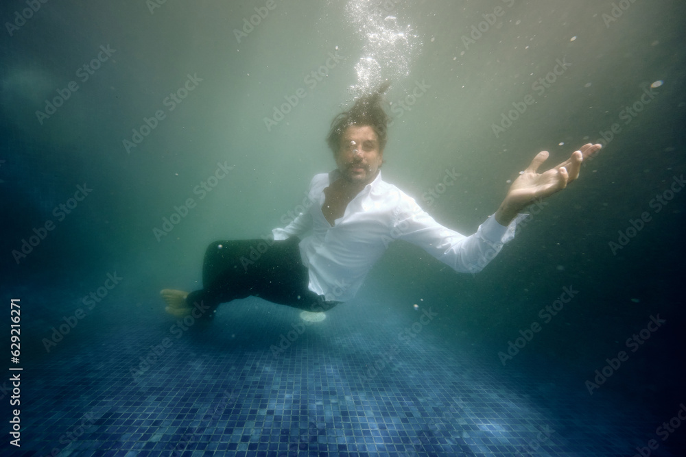 Sad man drowning in water in pool