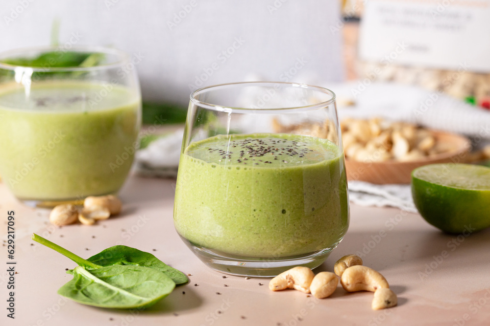 Revitalize with a Refreshing Green Cashew Smoothie on a glass: Vegan Blend of Spinach, Kale, and Banana, Creating a Creamy Plant-Based Delight Revitalize with a Refreshing Green Cashew Smoothie on a glass: Vegan Blend of Spinach, Kale, and Banana, Creating a Creamy Plant-Based Delight