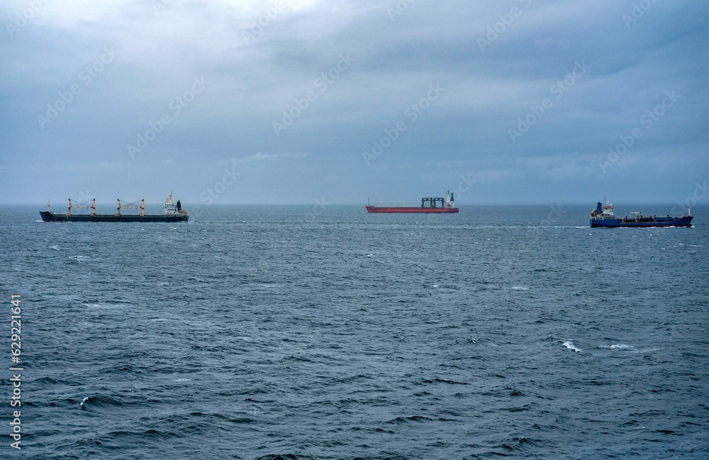 Transport auf dem Seeweg: Drei spezielle Transportschiffe mit unterschiedlicher Fracht begegnen sich auf einer Schifffahrtspassage mitten auf dem Meer, viel Copy Space
