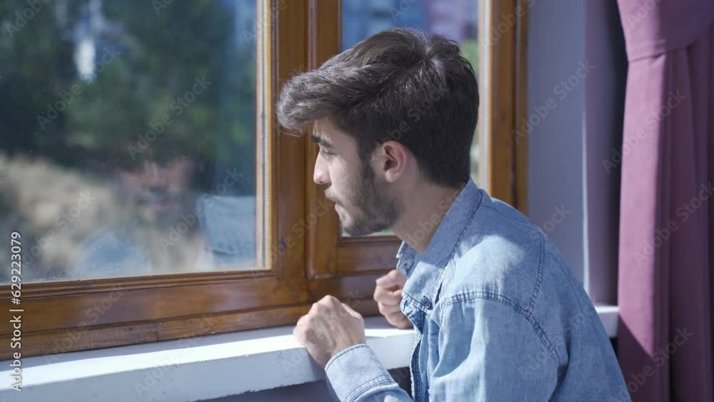 Worried and nervous man at home watching outside. Worried and nervous man at home watching outside.