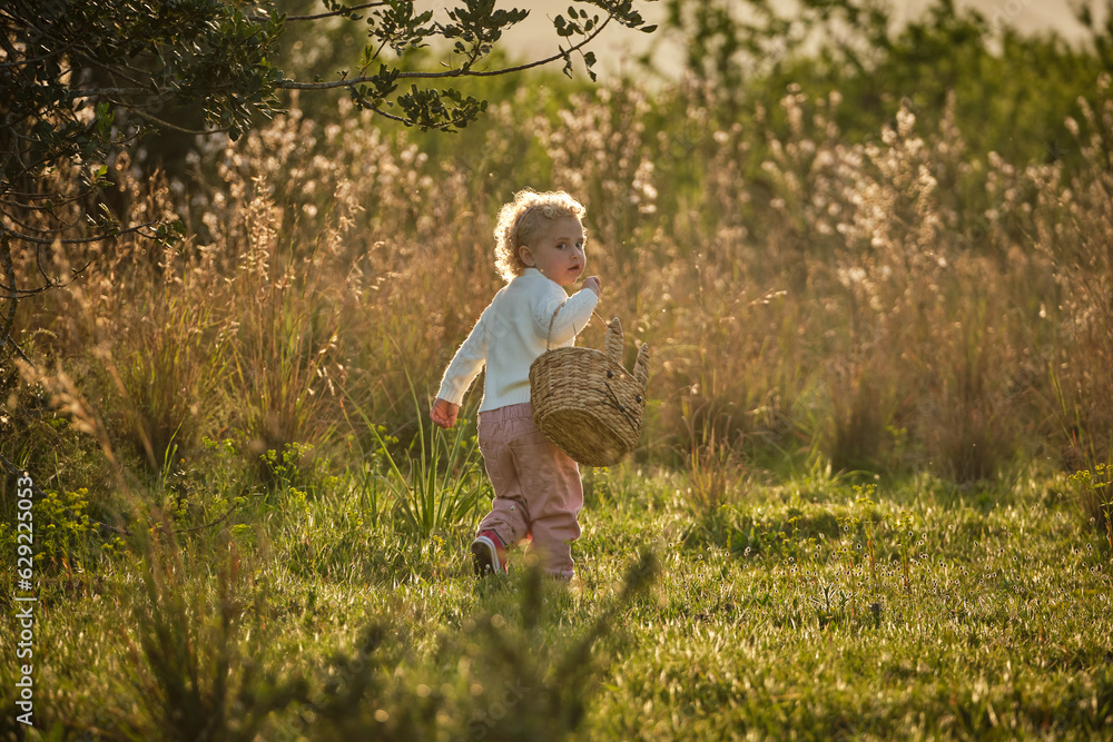 Cute girl with basket walking in summer garden Cute girl with basket walking in summer garden