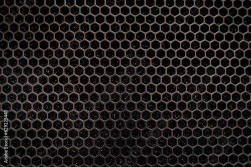 metal dark gray surface hexagonal holes. background texture for desktop wallpaper, screensaver. Bullet holes. Industrial model. Steel, aluminium. trypophobia