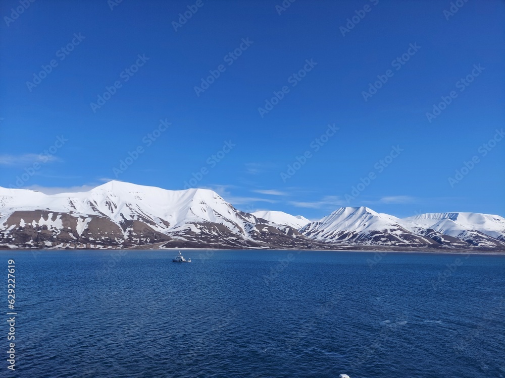 Serene Winter Landscape: Majestic Mountains, Pristine Snow, and Tranquil Sea a view from svalbard and jan mayen norway