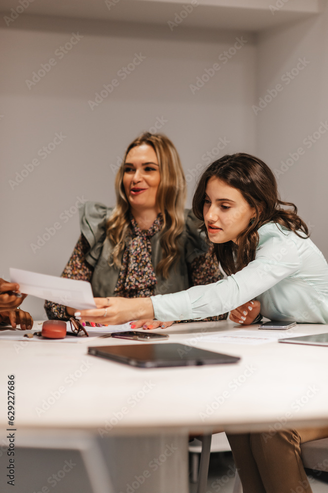 Business people sitting at desk doing paperwork together at the modern office Business people sitting at desk doing paperwork together at the modern office