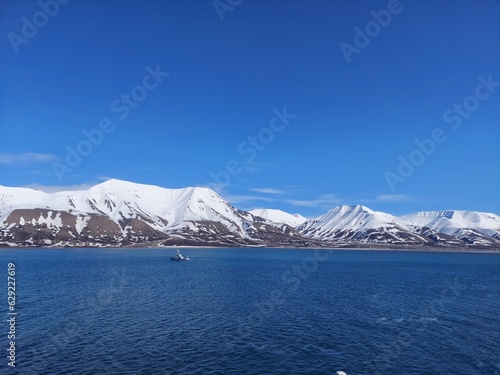 Serene Winter Landscape: Majestic Mountains, Pristine Snow, and Tranquil Sea a view from svalbard and jan mayen norway