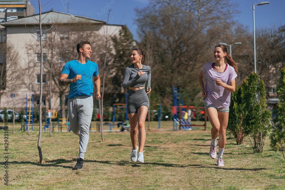 Friends having fun conversation and smiling while running outdoors