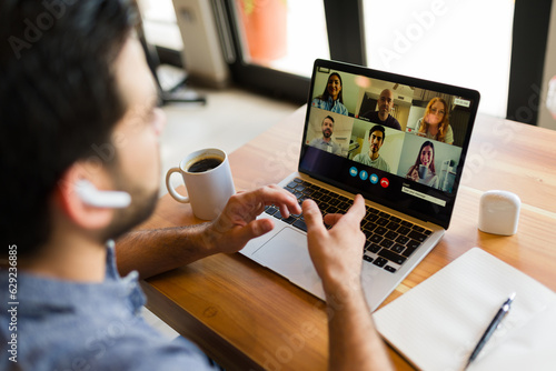 Rear view of a freelancer worker on a video call working remotely photo