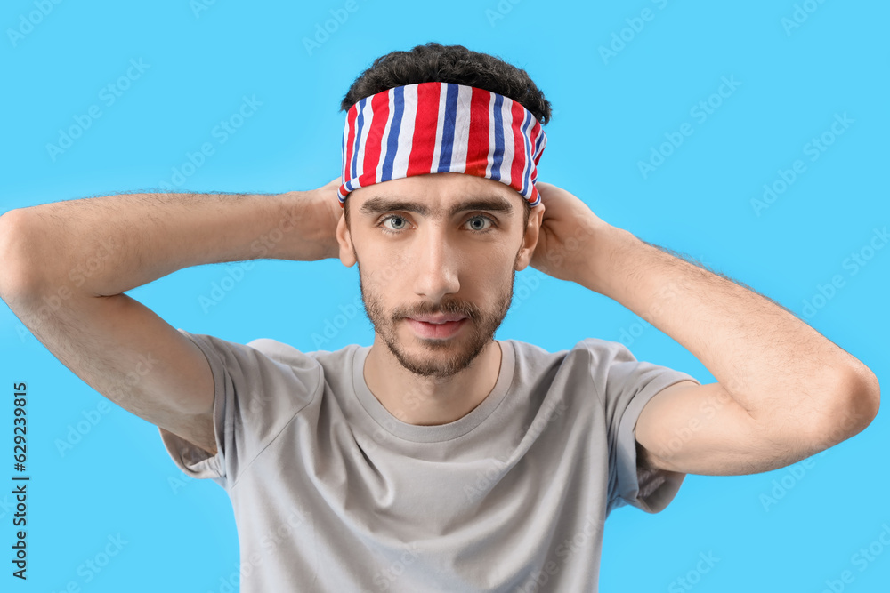 Young brunette man with stylish headscarf on blue background, closeup Young brunette man with stylish headscarf on blue background, closeup