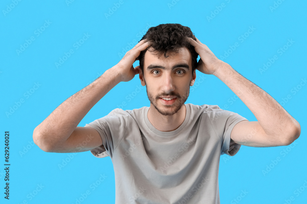 Young brunette man with stylish hairdo on blue background Young brunette man with stylish hairdo on blue background