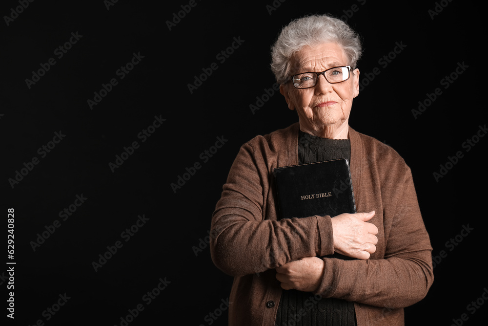 Senior woman with Holy Bible on black background Senior woman with Holy Bible on black background