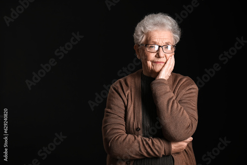 Senior woman in eyeglasses on black background © Pixel-Shot