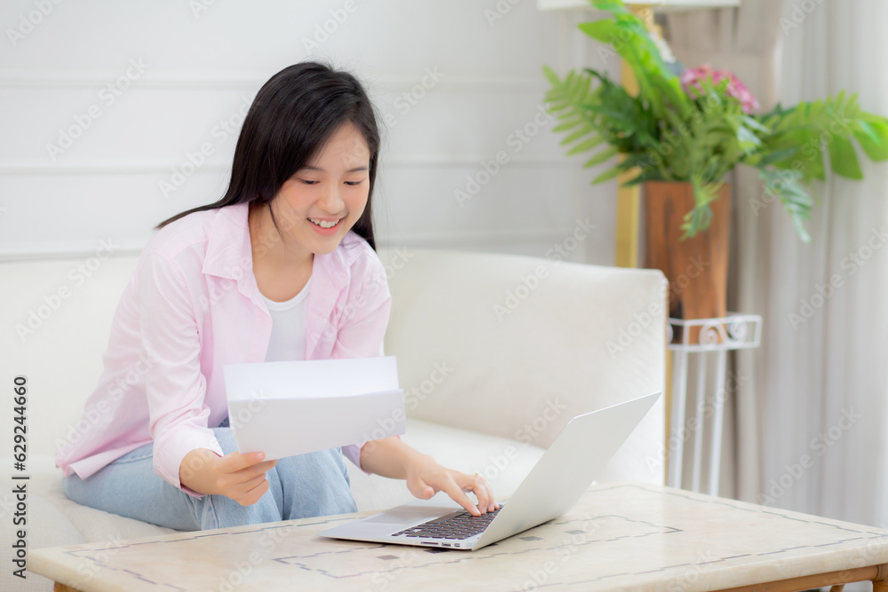 Young asian business woman working on laptop computer and looking graph and chart of report for profit on paper at home, businesswoman looking investment and income, data of infographic statistics. Young asian business woman working on laptop computer and looking graph and chart of report for profit on paper at home, businesswoman looking investment and income, data of infographic statistics.
