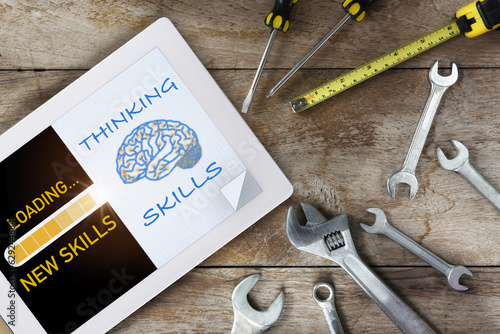 Artificial intelligence technology on digital tablet and brain thinking on white paper with tools supplies on wooden background