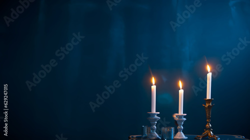 candlesticks with burning candles on dark blue background