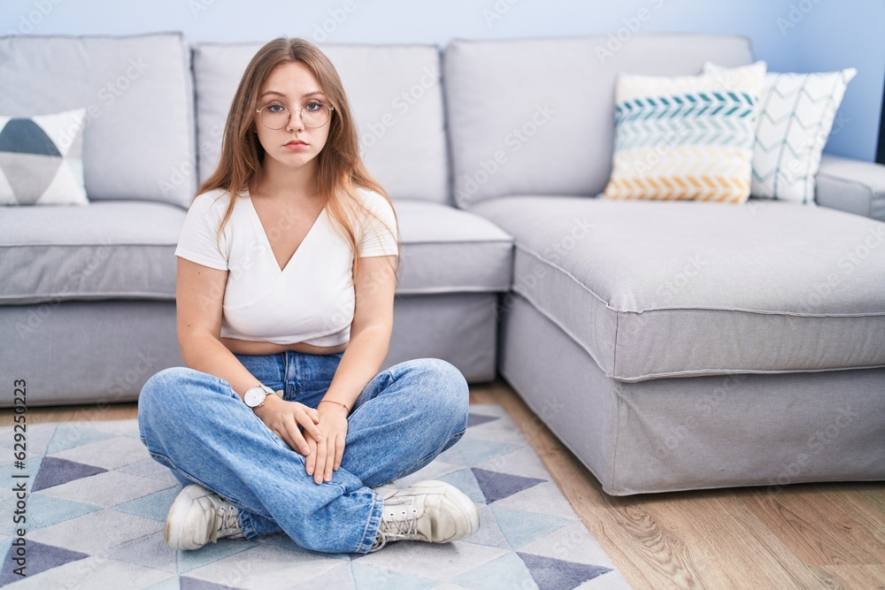 Young caucasian woman sitting on the floor at the living room depressed and worry for distress, crying angry and afraid. sad expression.