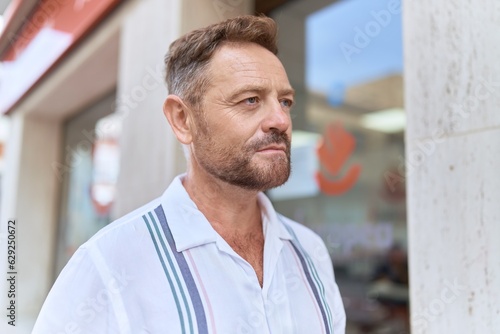 Middle age man looking to the side with serious expression at street